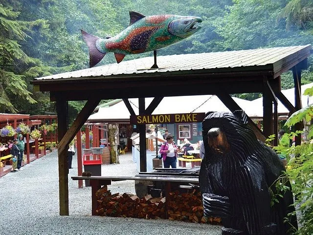 Pabellón al aire libre para asado de salmón con estatuas talladas de peces y osos cerca de Mendenhall.
